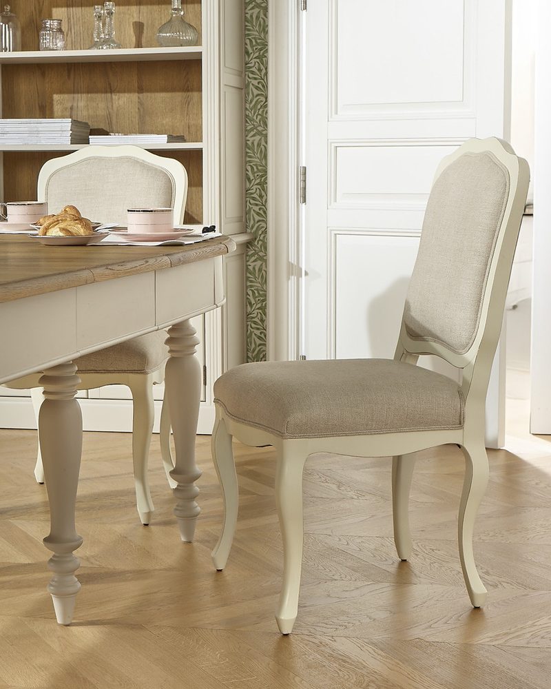 Cream dining chair beside a table in a bright room